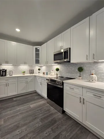 a kitchen with granite countertop white cabinets and white appliances