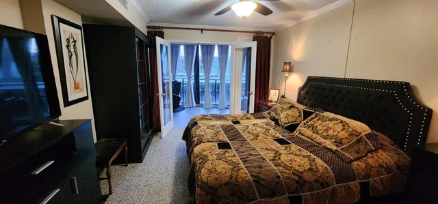 a bedroom with a bed lamp and a flat tv screen