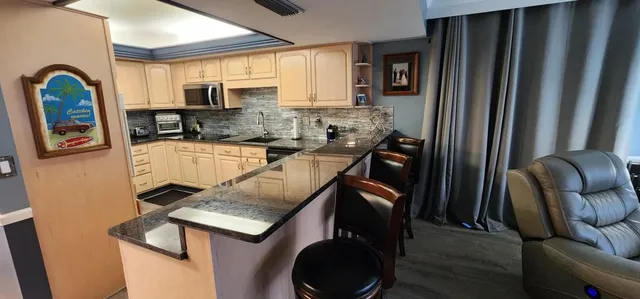 a kitchen with stainless steel appliances granite countertop a refrigerator a stove top oven a sink and dishwasher