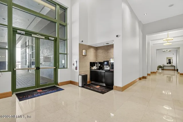 a dining hall with stainless steel appliances kitchen island granite countertop a table chairs and a living room view