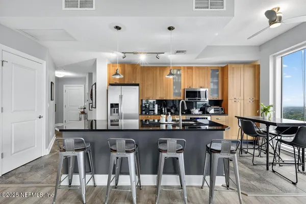 a living room with furniture floor to ceiling window hardwood floor and a flat screen tv