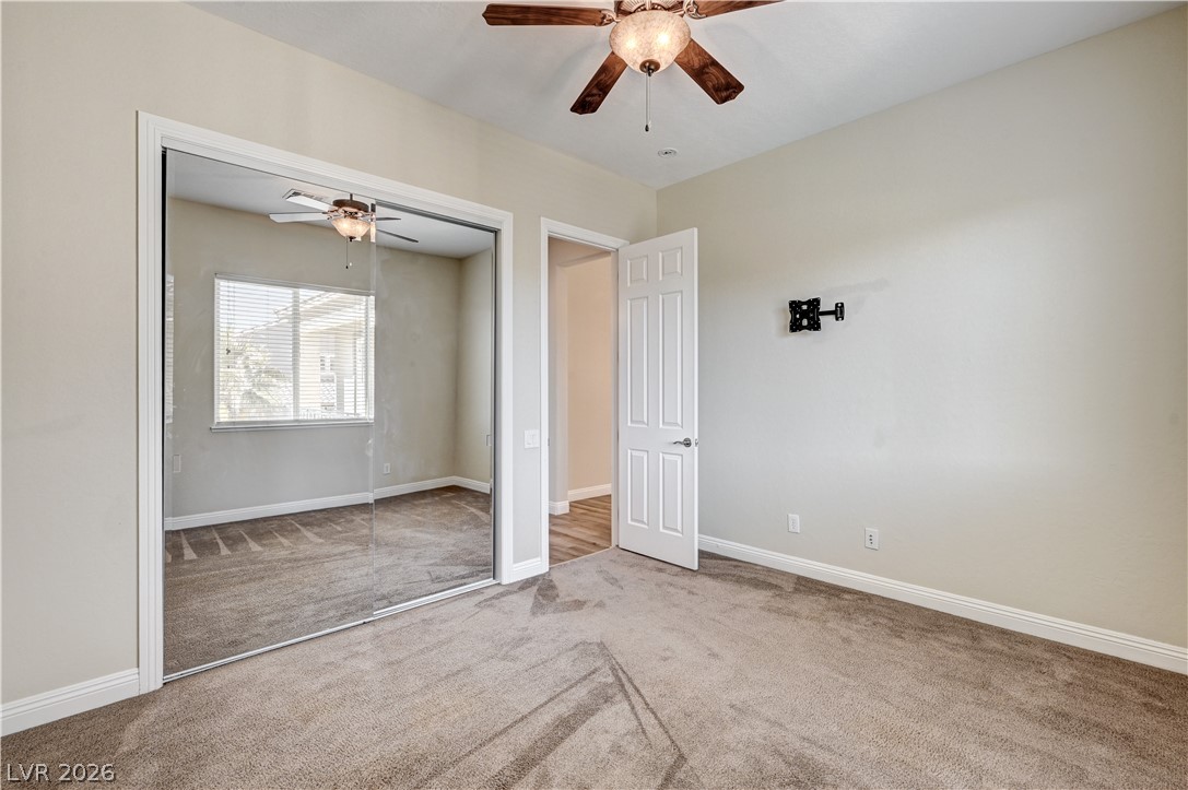 2793 Rosenhearty Drive Henderson, NV 89044 - Photo 48 of 77 A comfortable retreat features plush carpeting and a large mirrored closet, enhancing the sense of space.