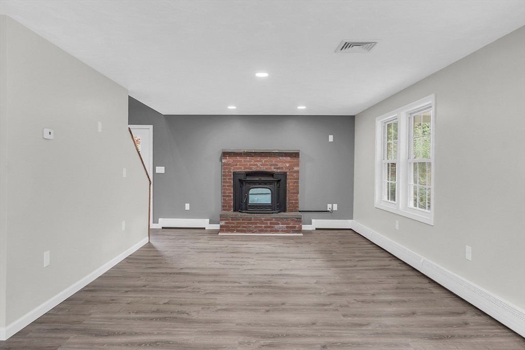 59 Molasses Hill Road Brookfield, MA 01506 - Photo 14 of 42 a view of an empty room with wooden floor fireplace and a window
