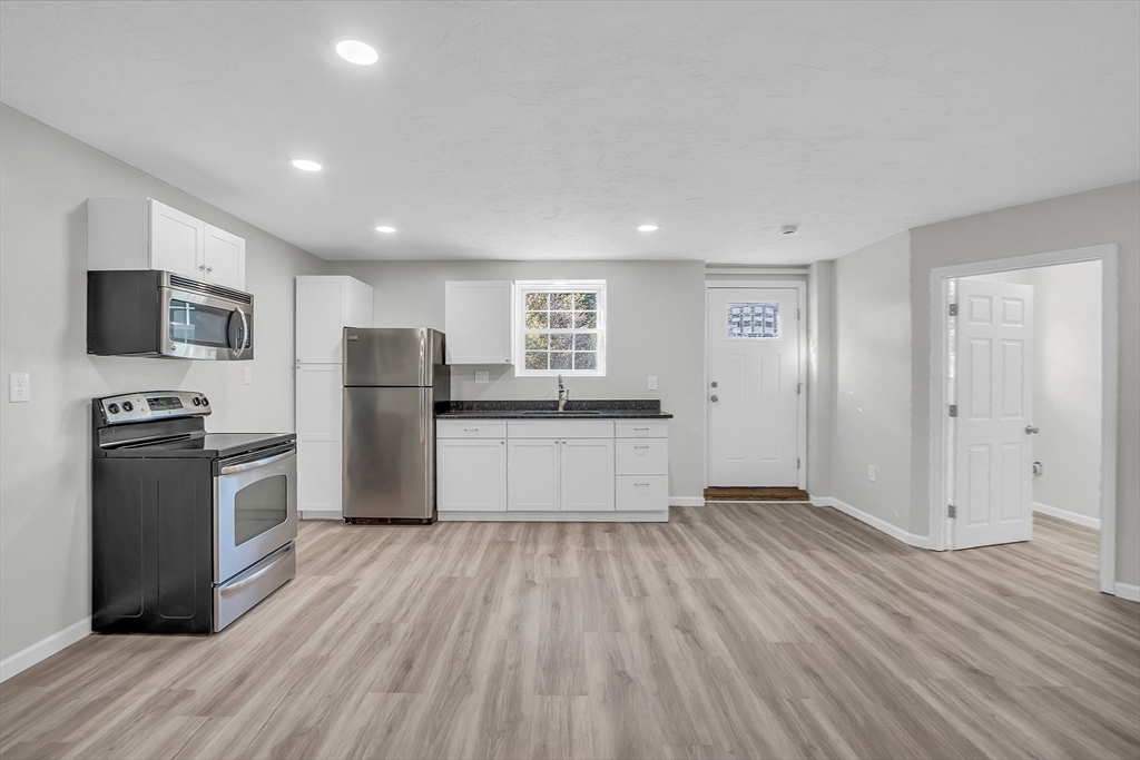 59 Molasses Hill Road Brookfield, MA 01506 - Photo 20 of 42 a large kitchen with a wooden floor and stainless steel appliances