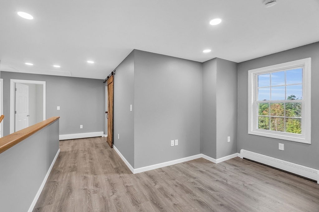 59 Molasses Hill Road Brookfield, MA 01506 - Photo 22 of 42 an empty room with wooden floor and windows
