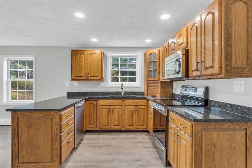 59 Molasses Hill Road Brookfield, MA 01506 - Photo 10 of 42 a kitchen with stainless steel appliances granite countertop a sink and dishwasher a stove with wooden cabinets