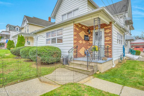 a view of a house with a yard and sitting area