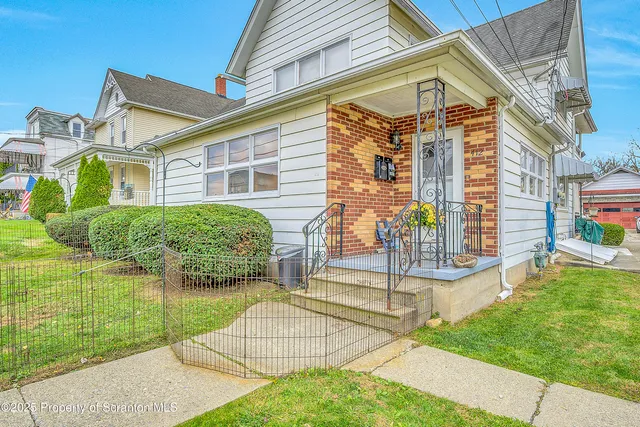 a view of a house with a yard and sitting area