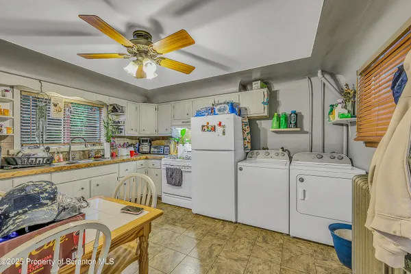 a very nice looking open kitchen with stainless steel appliances granite countertop a sink a stove a dining table and chairs