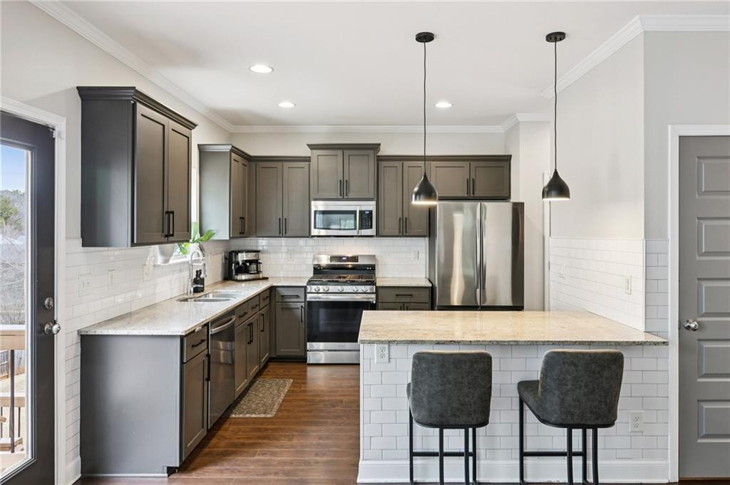 2358 Boulder Road Southeast Atlanta, GA 30316 - Photo 9 of 28 a kitchen with stainless steel appliances granite countertop a sink a stove a refrigerator and island with wooden floor
