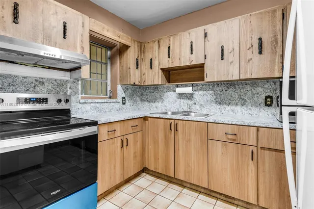a kitchen with stainless steel appliances granite countertop a refrigerator and a sink