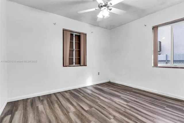 a view of a room with wooden floor and ceiling fan