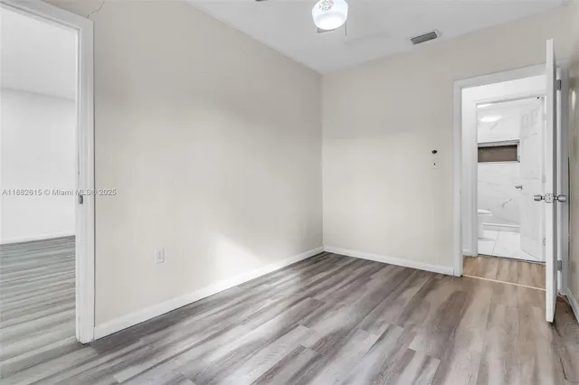 a view of empty room with window and ceiling fan