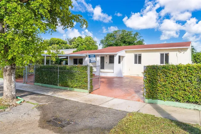 a view of a house with a yard and potted plants