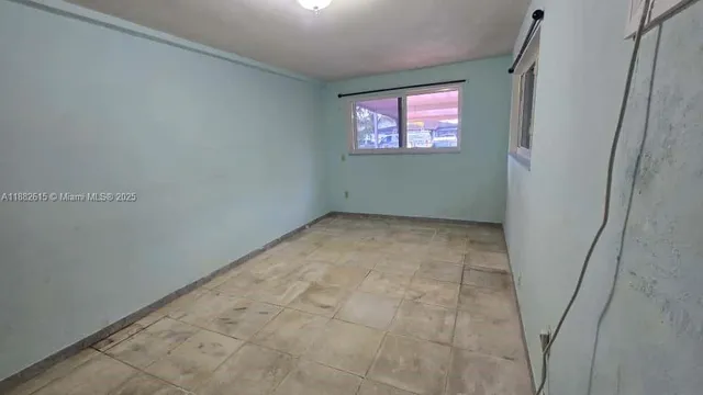 a view of a backyard with table and chairs potted plants and a palm tree