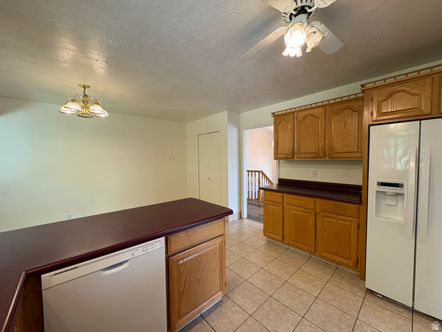 595 Meadowlark Road Orem, UT 84097 - Photo 23 of 87 Kitchen featuring wood-finish cabinetry, a central island with a built-in dishwasher, and tile flooring