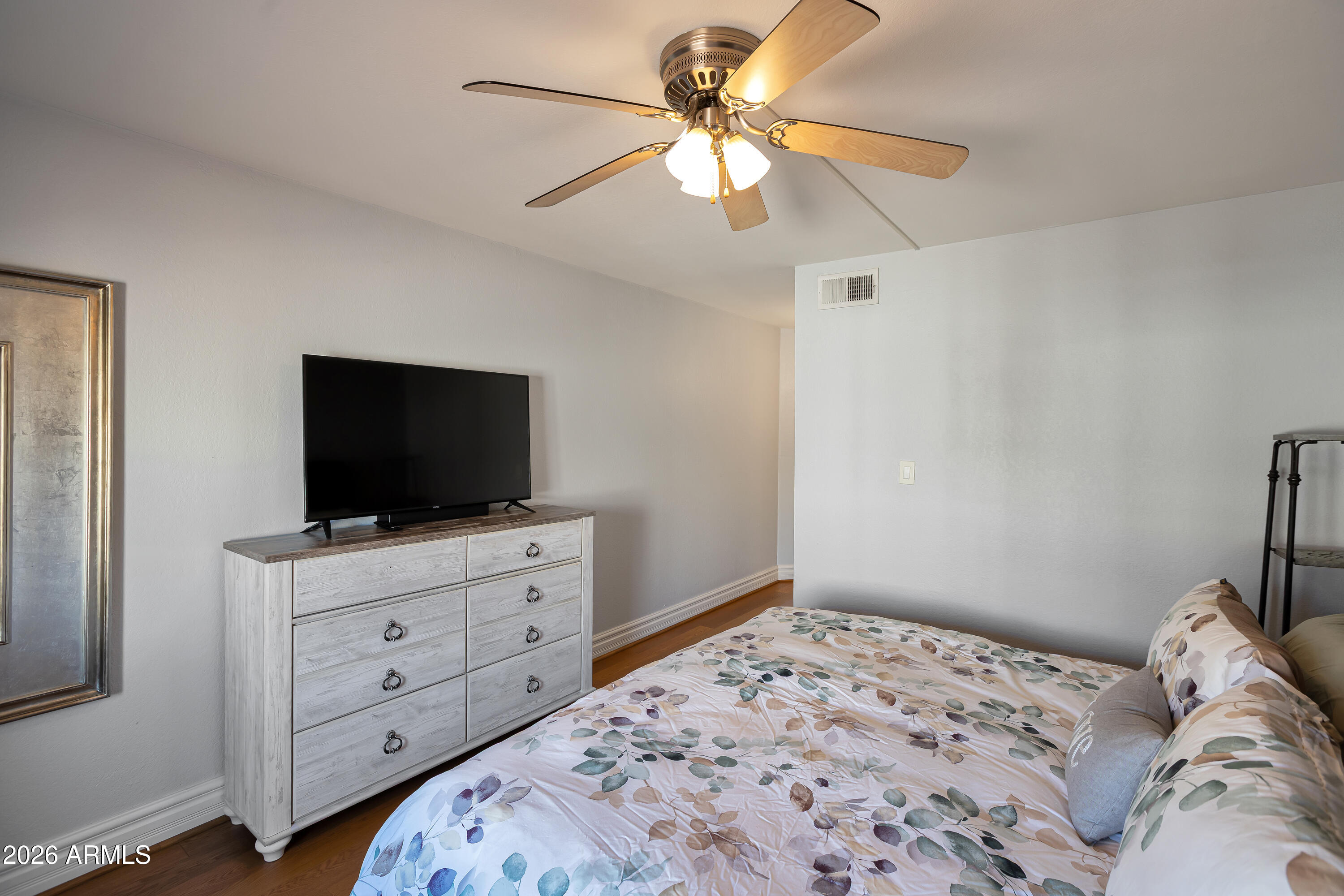 3825 East Camelback Road, Unit 218 Phoenix, AZ 85018 - Photo 9 of 28 a bedroom with a bed and a flat screen tv