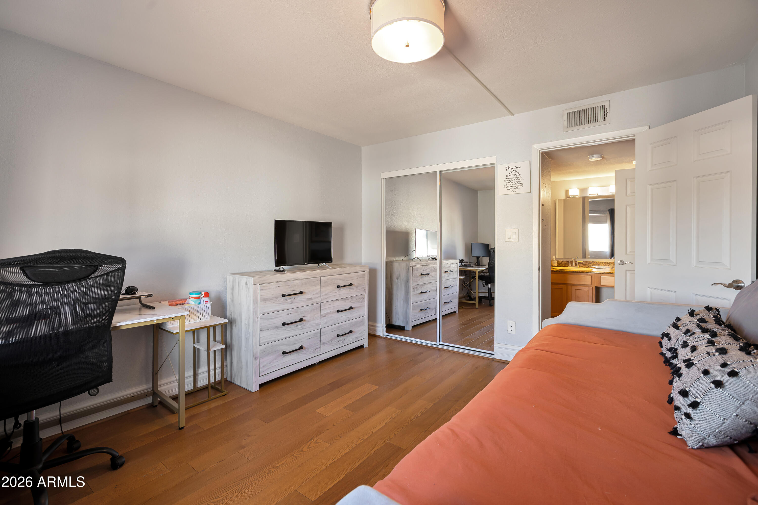 3825 East Camelback Road, Unit 218 Phoenix, AZ 85018 - Photo 17 of 28 a bedroom with furniture and flat screen tv