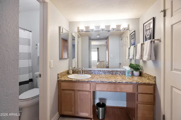 a bathroom with a granite countertop sink and a mirror