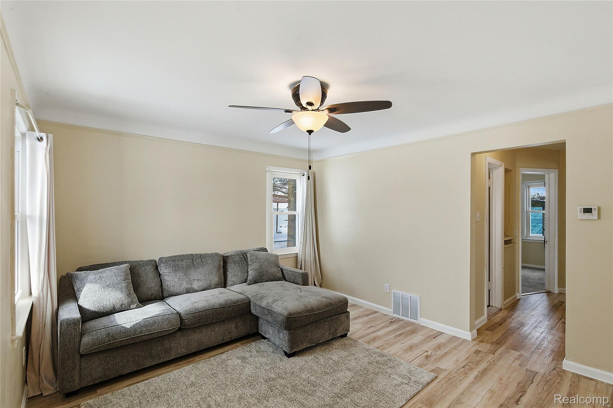 26104 Student Street Redford, MI 48239 - Photo 5 of 30 Living area with light wood-type flooring, ornamental molding, and ceiling fan