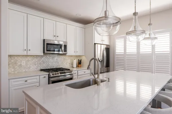 a kitchen with stainless steel appliances a sink a stove a microwave and cabinets