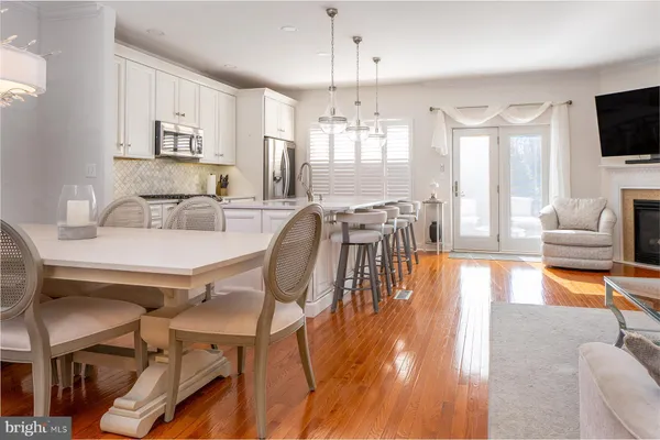 a dining room with wooden floor and large windows
