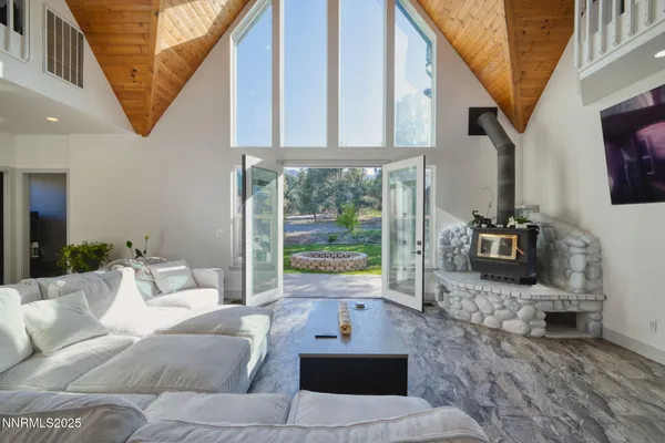 a living room with furniture a flat screen tv and a floor to ceiling window