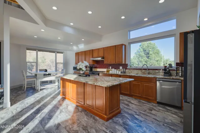 a kitchen with stainless steel appliances granite countertop sink stove top oven and cabinets