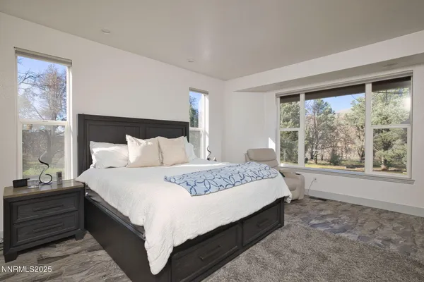 a large bed sitting in a bedroom next to a window