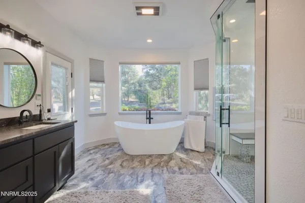 a spacious bathroom with a tub sink and mirror