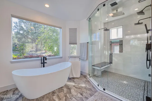 a white bath tub sitting in a bathroom next to a window