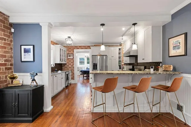 a kitchen with stainless steel appliances kitchen island granite countertop a view of living room and chairs