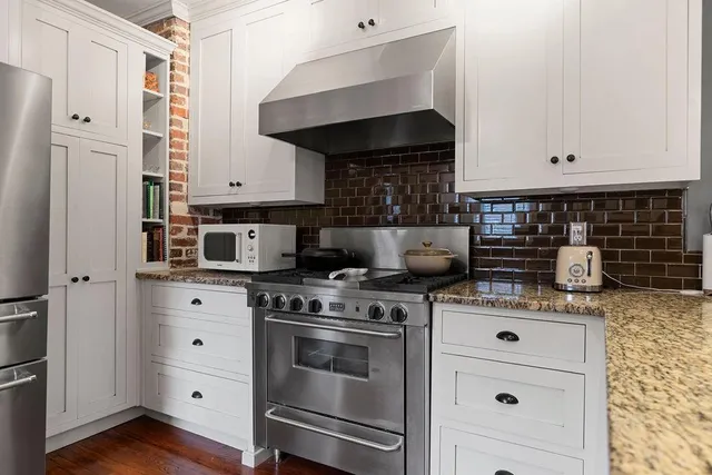 a kitchen with stainless steel appliances granite countertop a stove and a refrigerator
