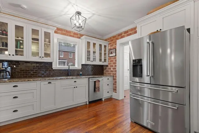 a kitchen with stainless steel appliances granite countertop a refrigerator and a stove top oven
