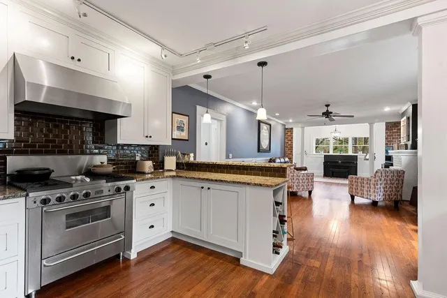 a large kitchen with cabinets wooden floor and stainless steel appliances