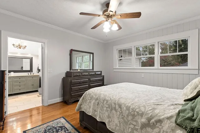 a bedroom with a large bed and a chandelier
