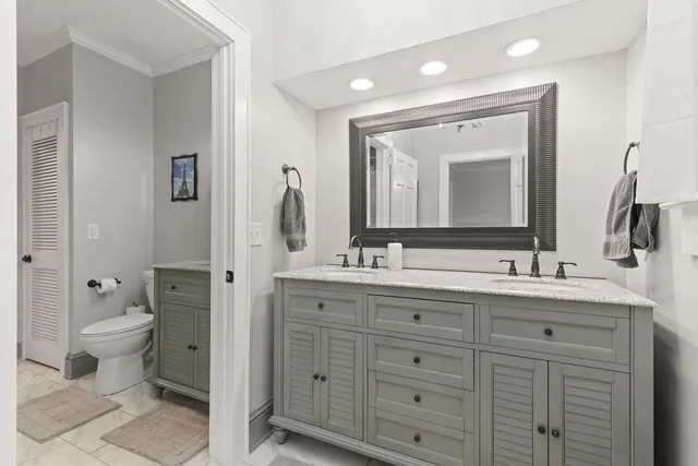 a bathroom with a toilet sink double and mirror