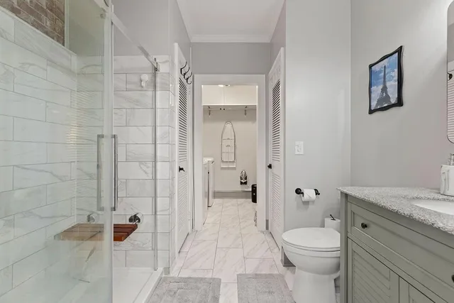 a bathroom with a granite countertop sink a toilet and shower