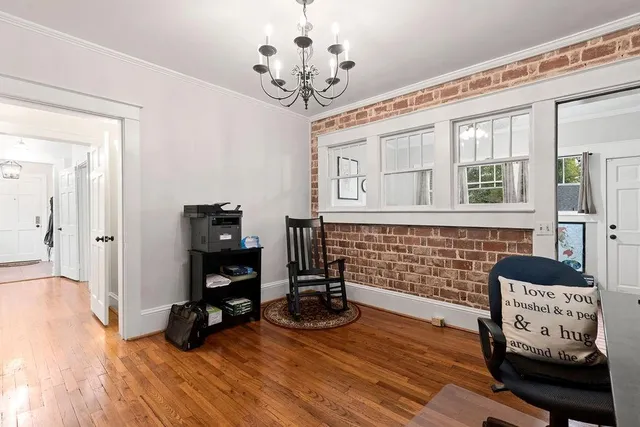 a view of a workspace with wooden floor and a chandelier