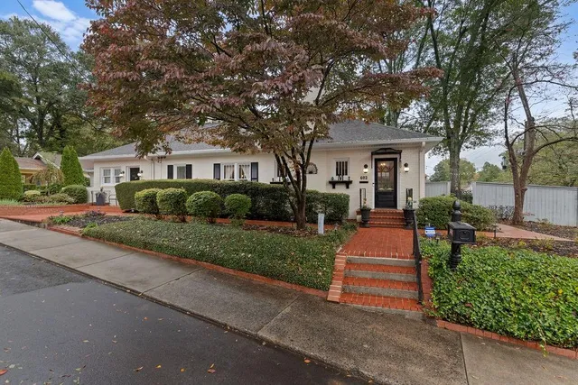 a front view of a house with a yard and potted plants
