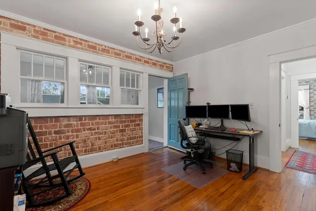 a view of a workspace with furniture and a window