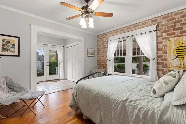 a large bedroom with a bed and wooden floor