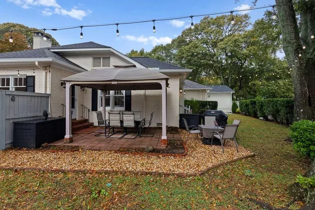 a view of a house with backyard and sitting area