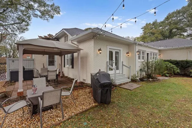 a view of a house with backyard and sitting area