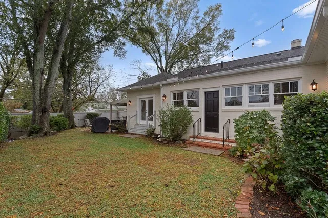 a view of a house with a yard and large tree