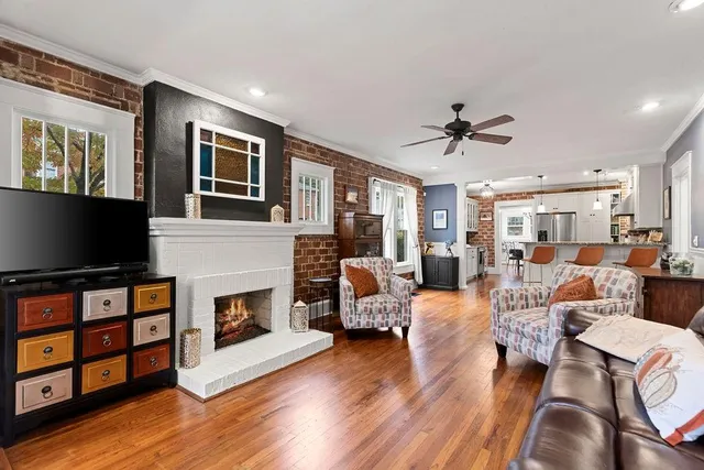 a living room with furniture a fireplace and a flat screen tv