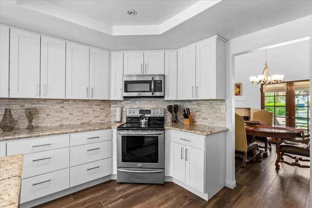 a kitchen with granite countertop white cabinets and white appliances