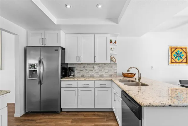 a kitchen with stainless steel appliances granite countertop a sink stove and refrigerator
