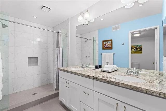 a bathroom with a granite countertop sink mirror and double