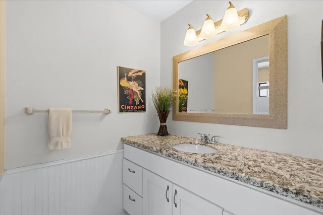 a bathroom with a granite countertop sink and a mirror